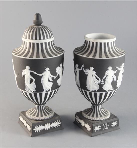A pair of Wedgwood black jasper urn shaped vases and a cover, c.1913, height 10.5in.
